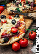 flavorful homemade pizza with bacon. hunk of delicious meat pizza with bacon and olives on the background of the vegetables.The image is tinted. Стоковое фото, агентство Ingram Publishing / Фотобанк Лори