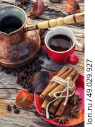 Coffee in the fall. Stylish porcelain Cup of coffee on  background decorated with spices and strewn with autumn leaves. Стоковое фото, агентство Ingram Publishing / Фотобанк Лори