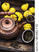 Fruit tea with quince. Copper kettle brewing and quinces in an old stylish derevna box. Стоковое фото, агентство Ingram Publishing / Фотобанк Лори