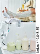 Pedicure treatment products with nourishing mask in woman leg. Стоковое фото, агентство Ingram Publishing / Фотобанк Лори