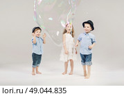 Two little gentlemen playing with their cute girlfriend. Стоковое фото, агентство Ingram Publishing / Фотобанк Лори