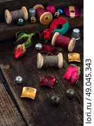 Beads,spools of thread on vintage wooden background . Стоковое фото, агентство Ingram Publishing / Фотобанк Лори