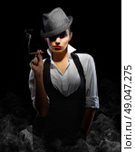Young woman in manly style with cigar on smoky background. Стоковое фото, агентство Ingram Publishing / Фотобанк Лори
