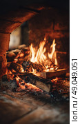 Cozy Fireplace With Crackling Flames and Glowing Embers During a Winter Evening. Стоковое AI-изображение, AI-художник Юлия Гапеенко / Фотобанк Лори