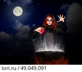 Young witch with red potion on night sky background. Стоковое фото, агентство Ingram Publishing / Фотобанк Лори