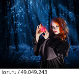 Young witch with potion at night forest. Стоковое фото, агентство Ingram Publishing / Фотобанк Лори