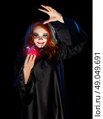 Young witch with red potion isolated. Стоковое фото, агентство Ingram Publishing / Фотобанк Лори