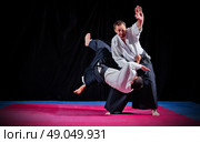 Fight between two aikido fighters on black. Стоковое фото, агентство Ingram Publishing / Фотобанк Лори