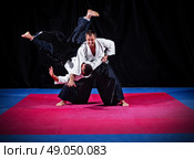 Fight between two aikido fighters on black. Стоковое фото, агентство Ingram Publishing / Фотобанк Лори