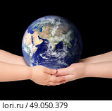 Child and woman holds earth globe on black. Стоковое фото, агентство Ingram Publishing / Фотобанк Лори