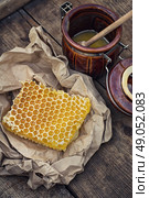 Honeycomb on piece of paper. Still life with honeycombs on  crumpled paper in rustic style. Стоковое фото, агентство Ingram Publishing / Фотобанк Лори
