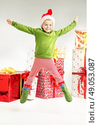 Cute jumping elf with gift in the bacground. Стоковое фото, агентство Ingram Publishing / Фотобанк Лори