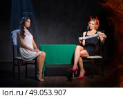 Angel and devil with playing cards on dark background. Стоковое фото, агентство Ingram Publishing / Фотобанк Лори