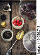 Varieties of tea. small cup with tea brewing in the background spoons and viburnum. Стоковое фото, агентство Ingram Publishing / Фотобанк Лори