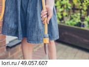 A young woman is standing outside in a garden and is holding a hose. Стоковое фото, агентство Ingram Publishing / Фотобанк Лори