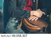 A young woman is sitting on a train and is clutching a handbag. Стоковое фото, агентство Ingram Publishing / Фотобанк Лори