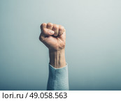 A clenched male fist is up in the air. Стоковое фото, агентство Ingram Publishing / Фотобанк Лори