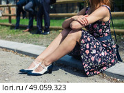 A young woman wearing a dress is sitting outside on a farm with smartly dressed people participating in a social event or gathering. Стоковое фото, агентство Ingram Publishing / Фотобанк Лори