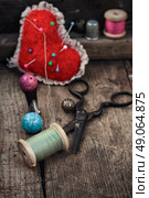 Old scissors,spools of thread,buttons and beads on wooden table. Стоковое фото, агентство Ingram Publishing / Фотобанк Лори