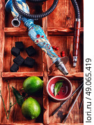 Accessories for Shisha. dismantled parts of the hookah in stylish wooden box with fruits lime. Стоковое фото, агентство Ingram Publishing / Фотобанк Лори