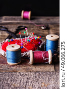 pin cushion with needles,thread and buttons for sewing on stylish wooden background. Стоковое фото, агентство Ingram Publishing / Фотобанк Лори