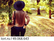 Street fashion concept - closeup portrait of a pretty girl. Wearing hat and suede jacket holding bag with fringe. Beautiful autumn woman. . Стоковое фото, агентство Ingram Publishing / Фотобанк Лори