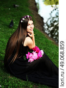 Beautiful hippy bohemian fashion style model in beautiful lake environment. Brunette woman with flowers enjoying nature against nature background. Стоковое фото, агентство Ingram Publishing / Фотобанк Лори