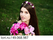 Beautiful hippy bohemian fashion style model in beautiful lake environment. Brunette woman with flowers enjoying nature against nature background. Стоковое фото, агентство Ingram Publishing / Фотобанк Лори
