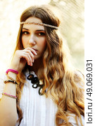 Fashion portrait of beautiful hippie young woman wearing boho chic clothes and summer hat outdoors. Soft warm vintage color tone. Artsy bohemian style. Стоковое фото, агентство Ingram Publishing / Фотобанк Лори