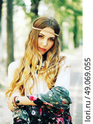 Fashion portrait of beautiful hippie young woman wearing boho chic clothes and summer hat outdoors. Soft warm vintage color tone. Artsy bohemian style. Стоковое фото, агентство Ingram Publishing / Фотобанк Лори