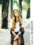 Fashion portrait of beautiful hippie young woman wearing boho chic clothes and summer hat outdoors. Soft warm vintage color tone. Artsy bohemian style. Стоковое фото, агентство Ingram Publishing / Фотобанк Лори