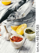 Thawed fresh fish mackerel with spices and marinade with lemon.Photograph high key. Carcasses frozen mackerel. Стоковое фото, агентство Ingram Publishing / Фотобанк Лори