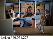 Architect woman in office warehouse talking mobile phone with paper project plan. Стоковое фото, агентство Ingram Publishing / Фотобанк Лори