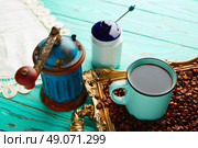 Coffee cup with vintage grinder on wooden old table and golden tray beans. Стоковое фото, агентство Ingram Publishing / Фотобанк Лори