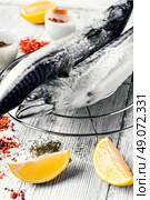Thawed fresh fish mackerel with spices and marinade.Photograph high key. Carcasses frozen mackerel. Стоковое фото, агентство Ingram Publishing / Фотобанк Лори