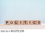 Politics sign made of wooden cubes on a blue background. Стоковое фото, агентство Ingram Publishing / Фотобанк Лори