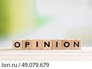 Opinion sign on a wooden indoor desk. Стоковое фото, агентство Ingram Publishing / Фотобанк Лори