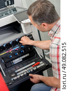 Man working on photocopier. Стоковое фото, агентство Ingram Publishing / Фотобанк Лори