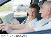 Elderly couple driving, wife pointing to map. Стоковое фото, агентство Ingram Publishing / Фотобанк Лори