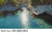 Hidden beach cove with crystal waters and rocky terrain in summer Kefalonia Greece. Стоковое видео, видеограф Igor Tichonow / Фотобанк Лори