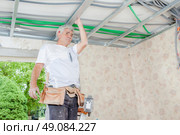 Builder  holding metal framework of ceiling. Стоковое фото, агентство Ingram Publishing / Фотобанк Лори
