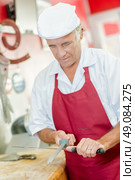Butcher sharpening a knife. Стоковое фото, агентство Ingram Publishing / Фотобанк Лори