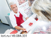 Butcher serving one of his customers. Стоковое фото, агентство Ingram Publishing / Фотобанк Лори