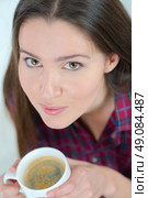 Woman drinking a cup of coffee on the sofa. Стоковое фото, агентство Ingram Publishing / Фотобанк Лори