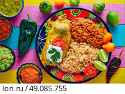 Chili relleno chili pepper poblano filled with cheese in dish with with rice and frijoles beans. Стоковое фото, агентство Ingram Publishing / Фотобанк Лори