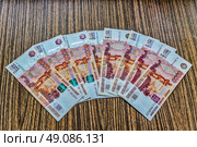 Российские деньги-бумажные купюры достоинством 5000 рублей лежат на столе. Стоковое фото, фотограф Владимир Устенко / Фотобанк Лори