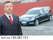 Portrait of funeral director standing in front of hearse. Стоковое фото, агентство Ingram Publishing / Фотобанк Лори