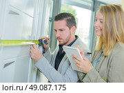 man measuring a fitted cupboard. Стоковое фото, агентство Ingram Publishing / Фотобанк Лори