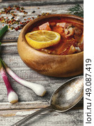 Dish of Russian cuisine-beef stew. Traditional Solyanka with smoked meats in wooden plate. Стоковое фото, агентство Ingram Publishing / Фотобанк Лори
