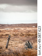 Barb wire on a fence in cloudy weather on a battlefield. Стоковое фото, агентство Ingram Publishing / Фотобанк Лори
